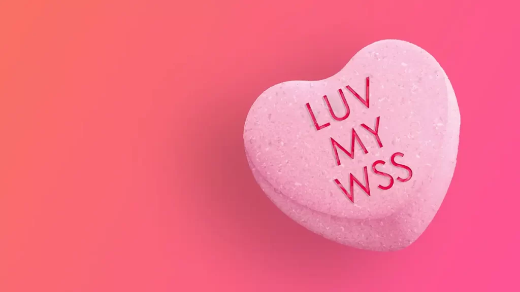 A candy heart that says "LUV MY WSS" on a pink background